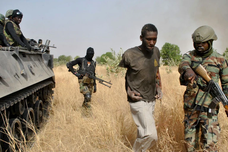 Men in army uniform directing a captured man