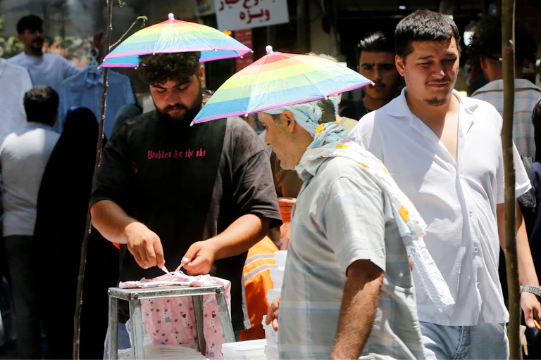 People in the streets of Tehran wearing sunshade umbrella-type hats because of very high temperatures.