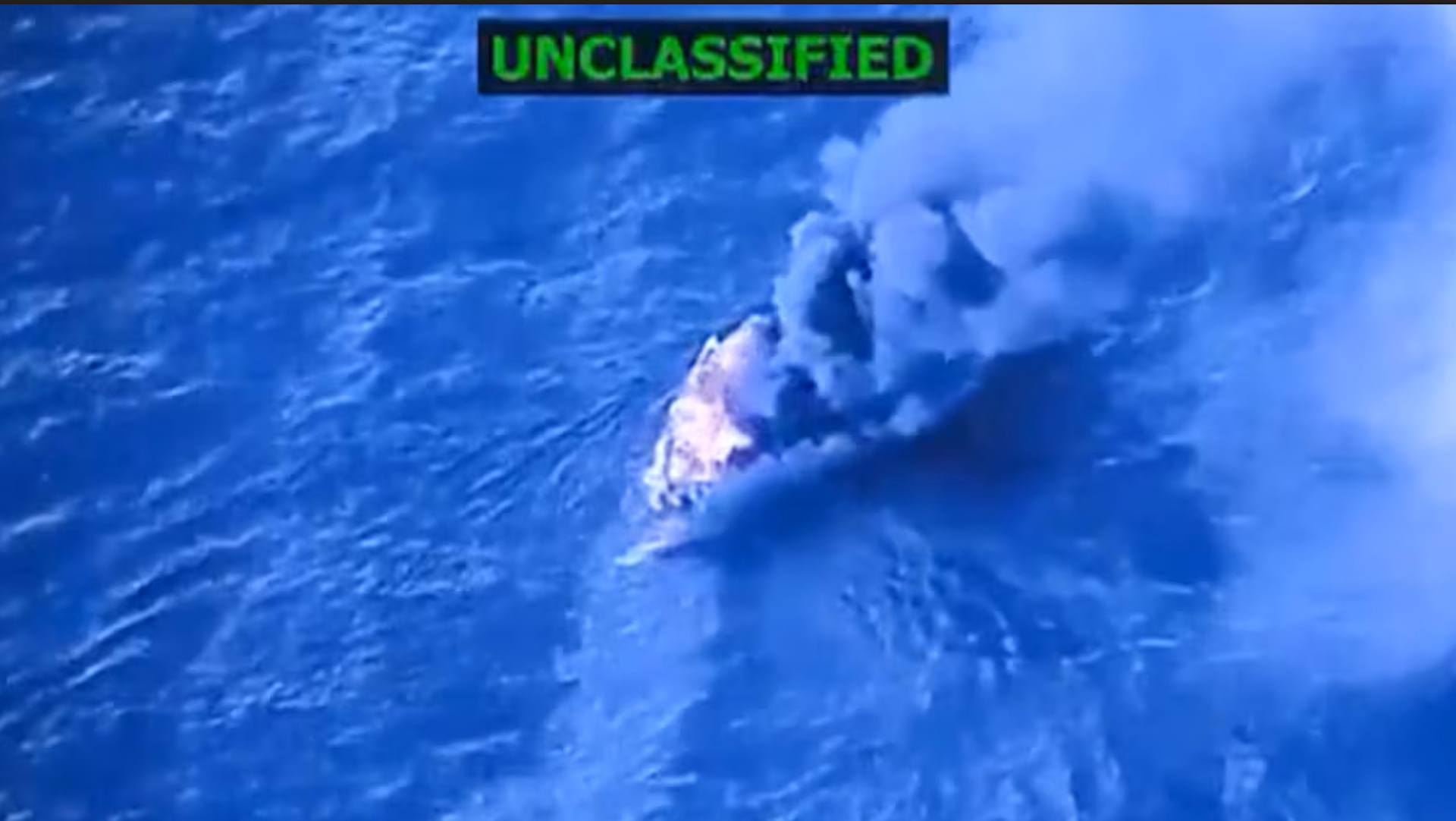 Imagen cenital de una embarcación de la que sale unas espesa columna de humo.