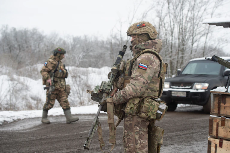 Two Russian soldiers inspect vehicles at a checkpoint in Zaporizhia