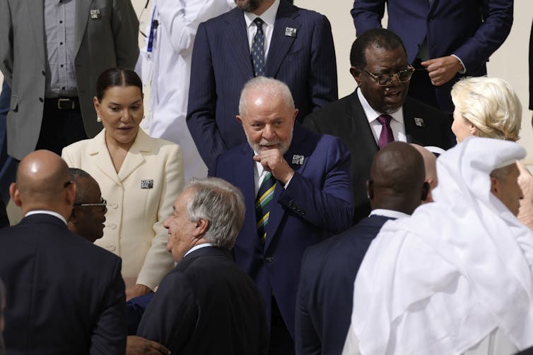 Lula da Silva stands in a group talking, including heads of the UN and EU.
