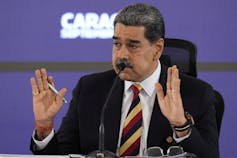 El político proekmocrático venezolano ganó el Premio Nobel de la Paz de este año. ¿Eso es una reprimenda para Trump? 3 Un hombre con el pelo corto y oscuro y un gesto de bigote con las manos mientras habla.