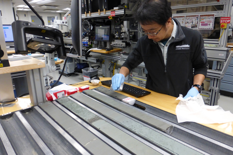 La historia de rápido derretimiento de la Antártida Occidental predice cambios repentinos en la geología 'catastrófica' del continente 1 Una persona mira largas bandas de roca grises.