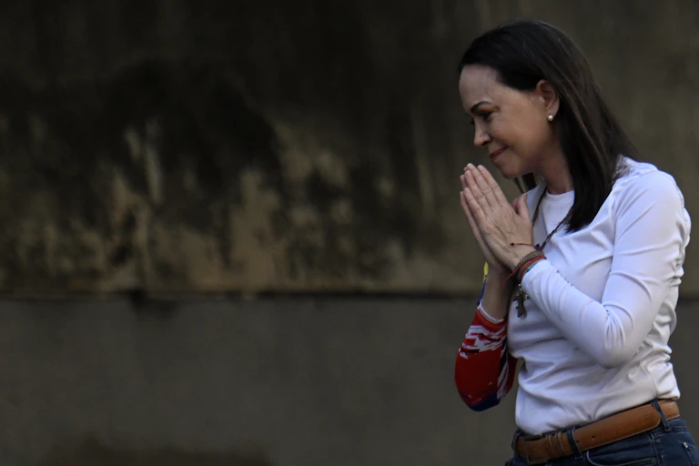 A woman. in white clasps here hands.