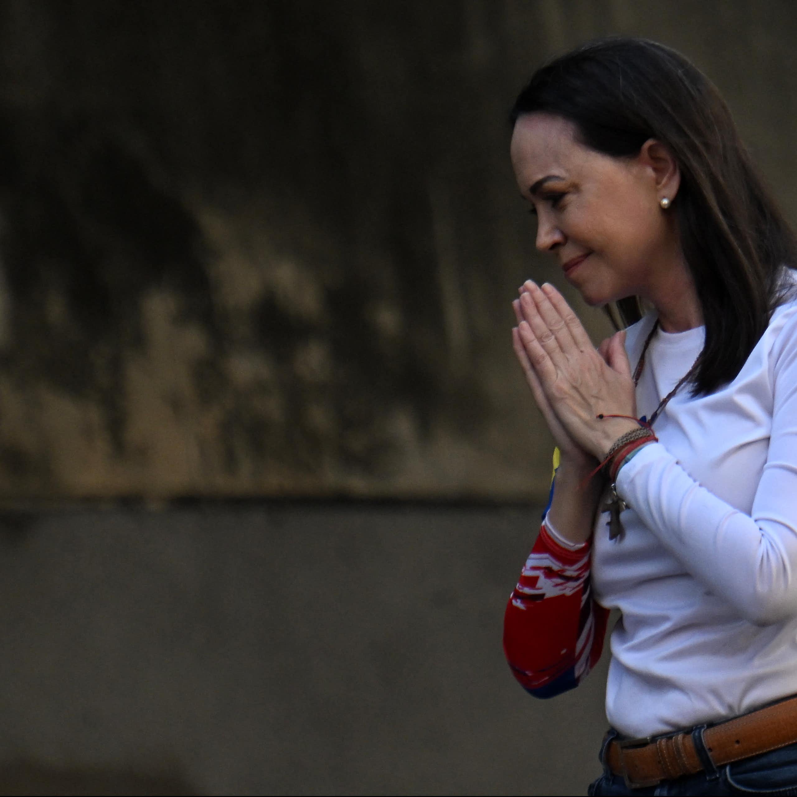 A woman. in white clasps here hands.