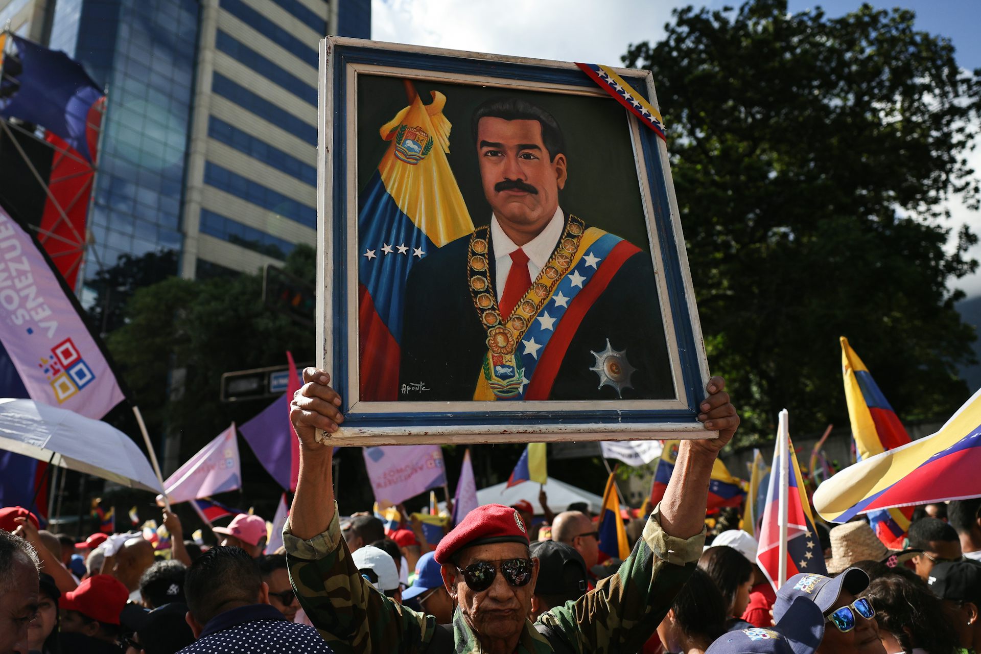 A large painting of a man is held aloft.
