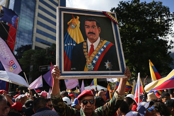 A large painting of a man is held aloft.