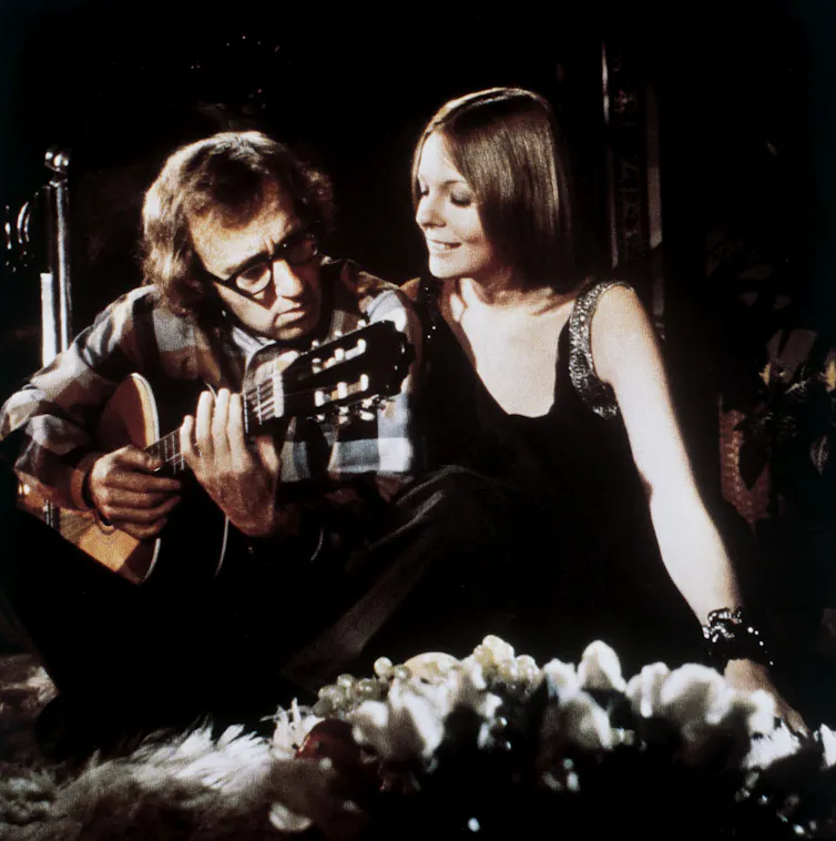 Allen toca la guitarra mientras Keaton lo observa.
