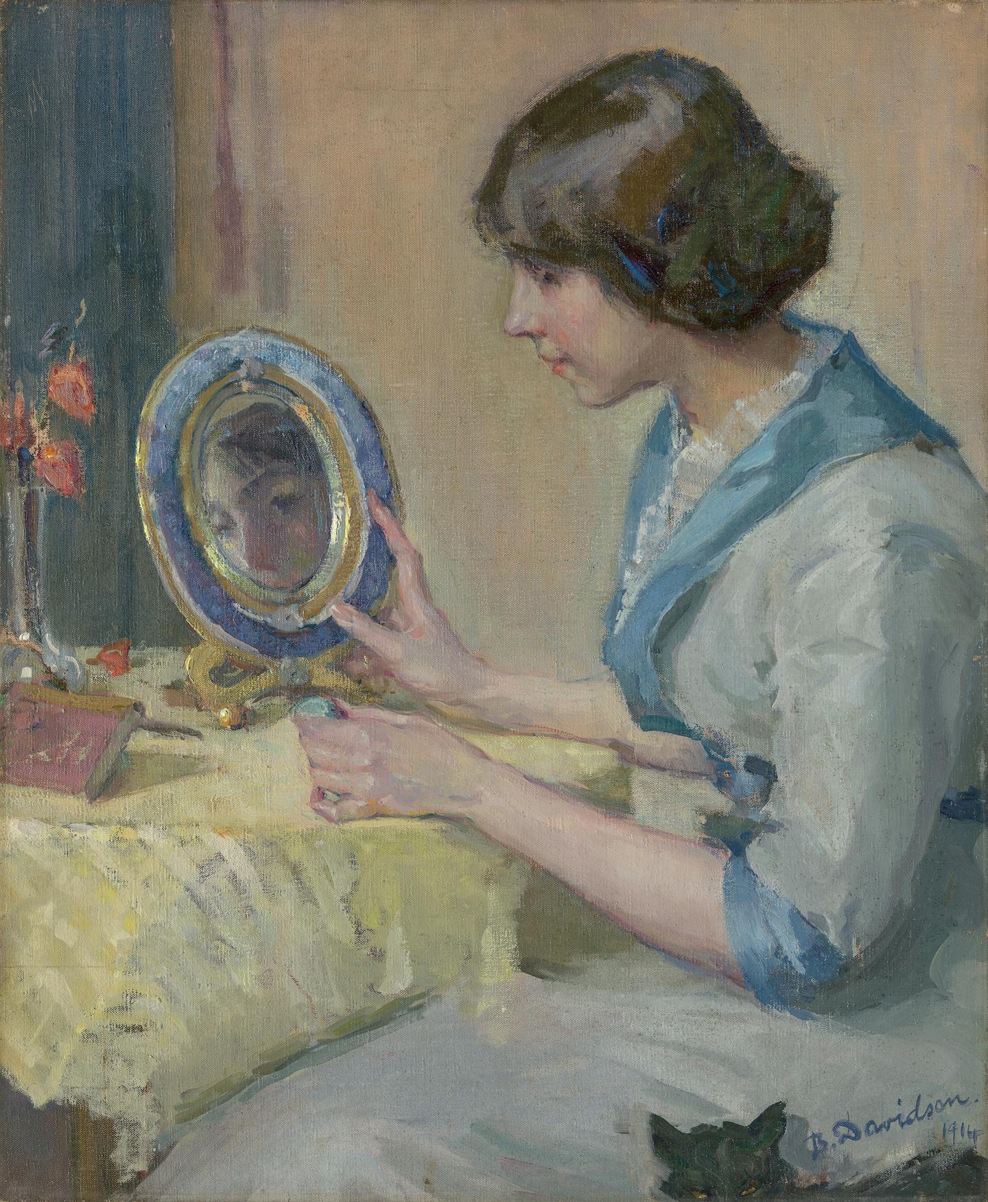 A girl looks into a small mirror.
