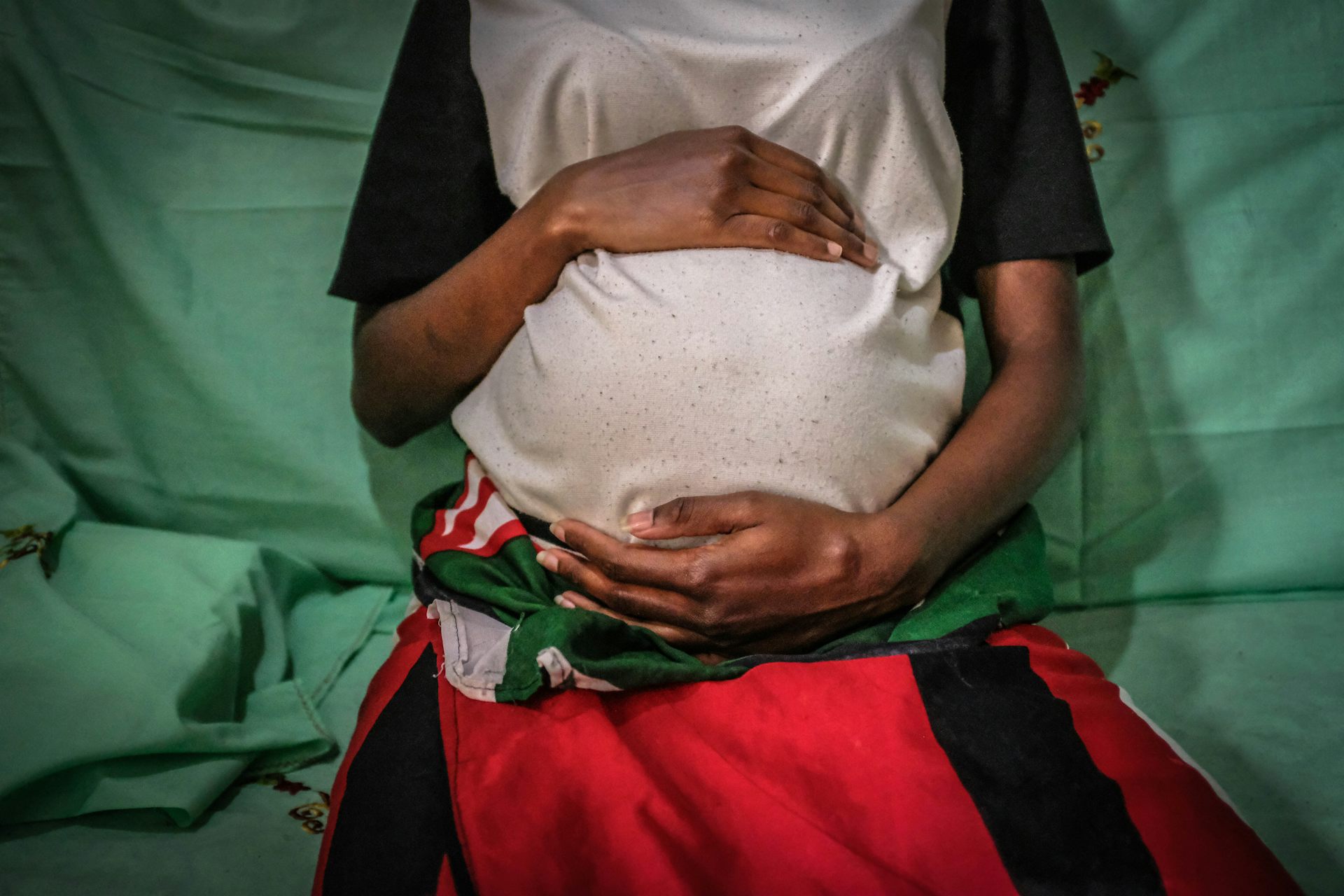 A pregnant young woman holding her belly