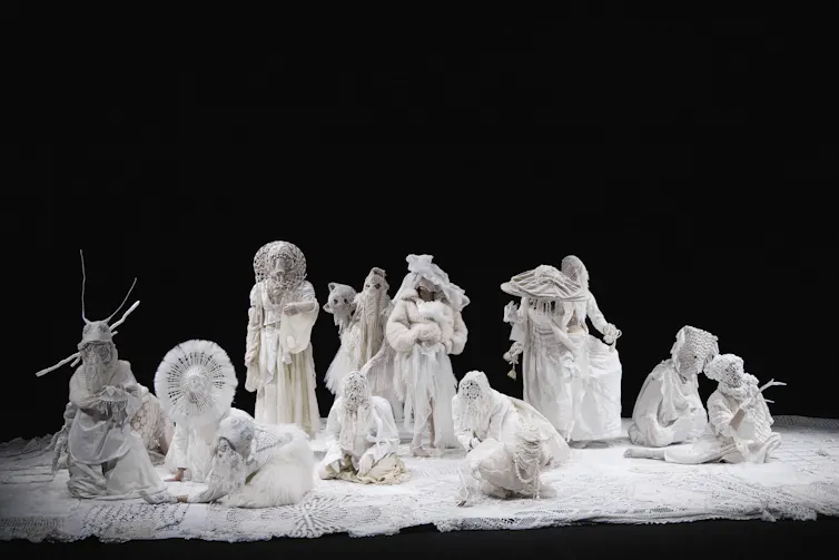 A tableau of people dressed in ornate white lace.
