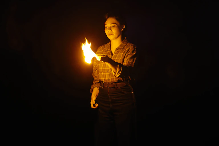 A woman holds a flame.