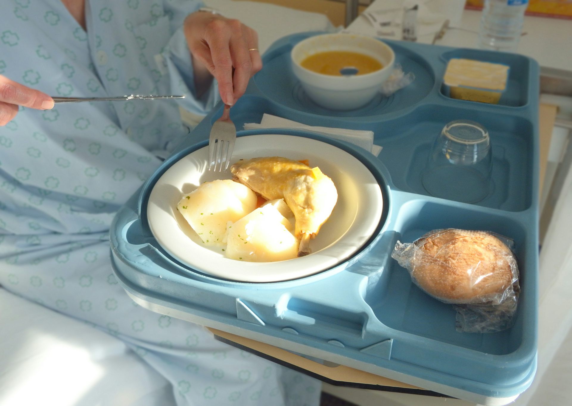 Tray of hospital food including mash potato and a bread roll