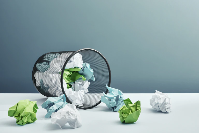 crumpled paper in a wire bin