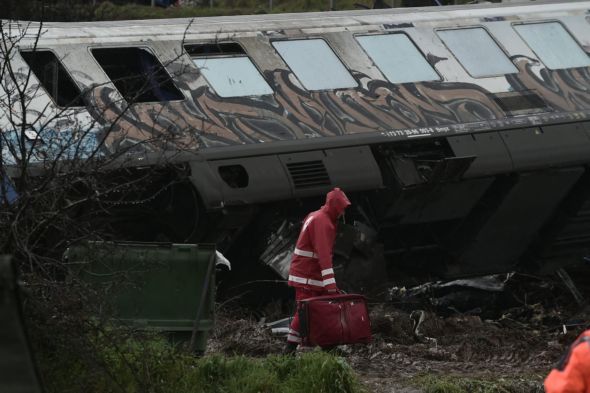 Un sauveteur devant un wagon de train accidenté.