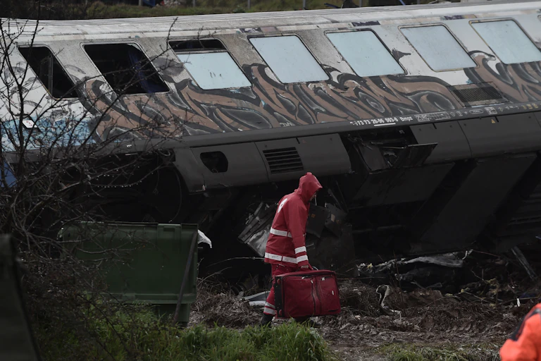 Un sauveteur devant un wagon de train accidenté.