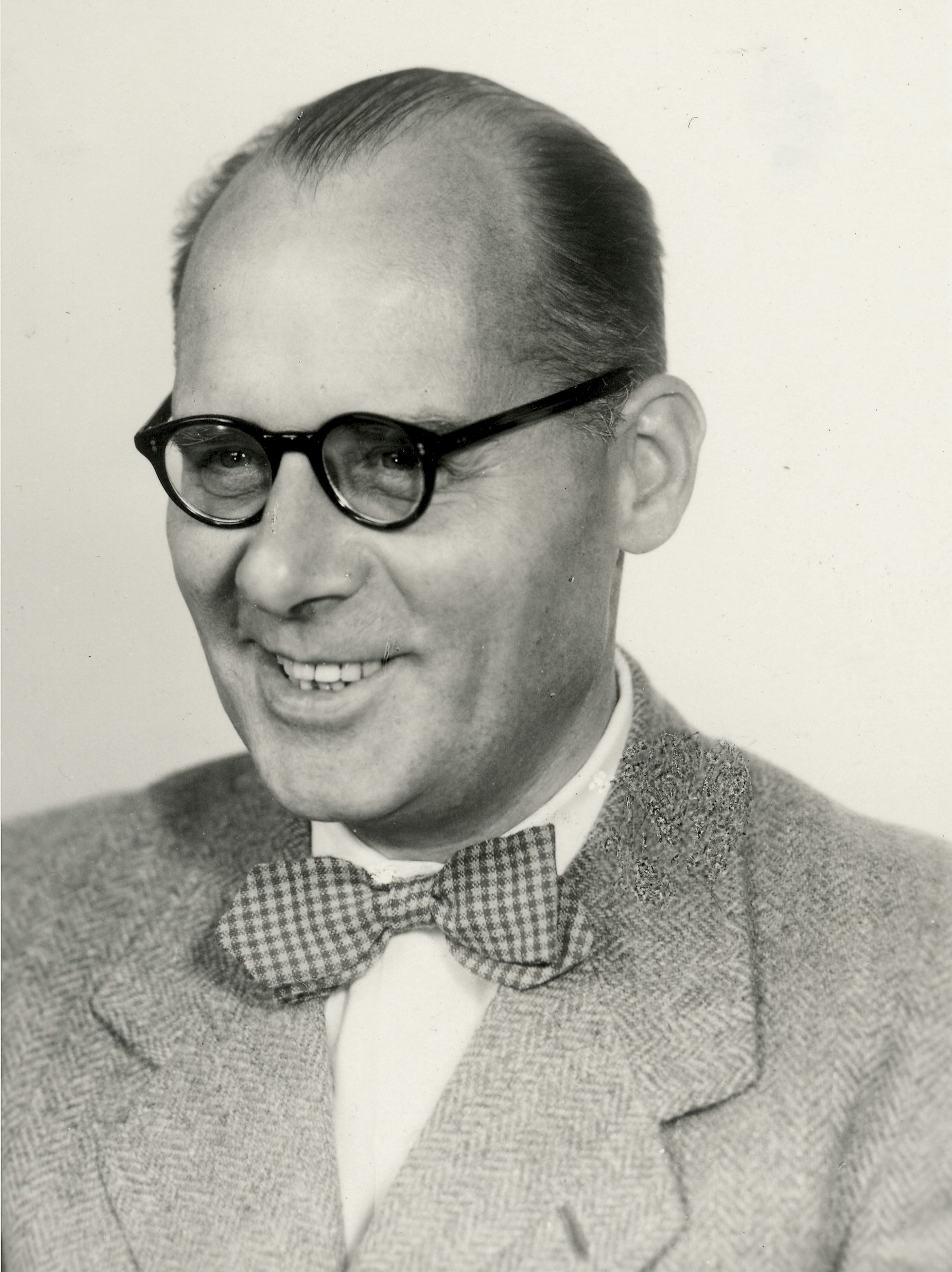 Black and white portait photo of man wearing bow tie.