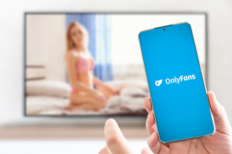 Personne avec un portable ouvrant l'application OnlyFans.