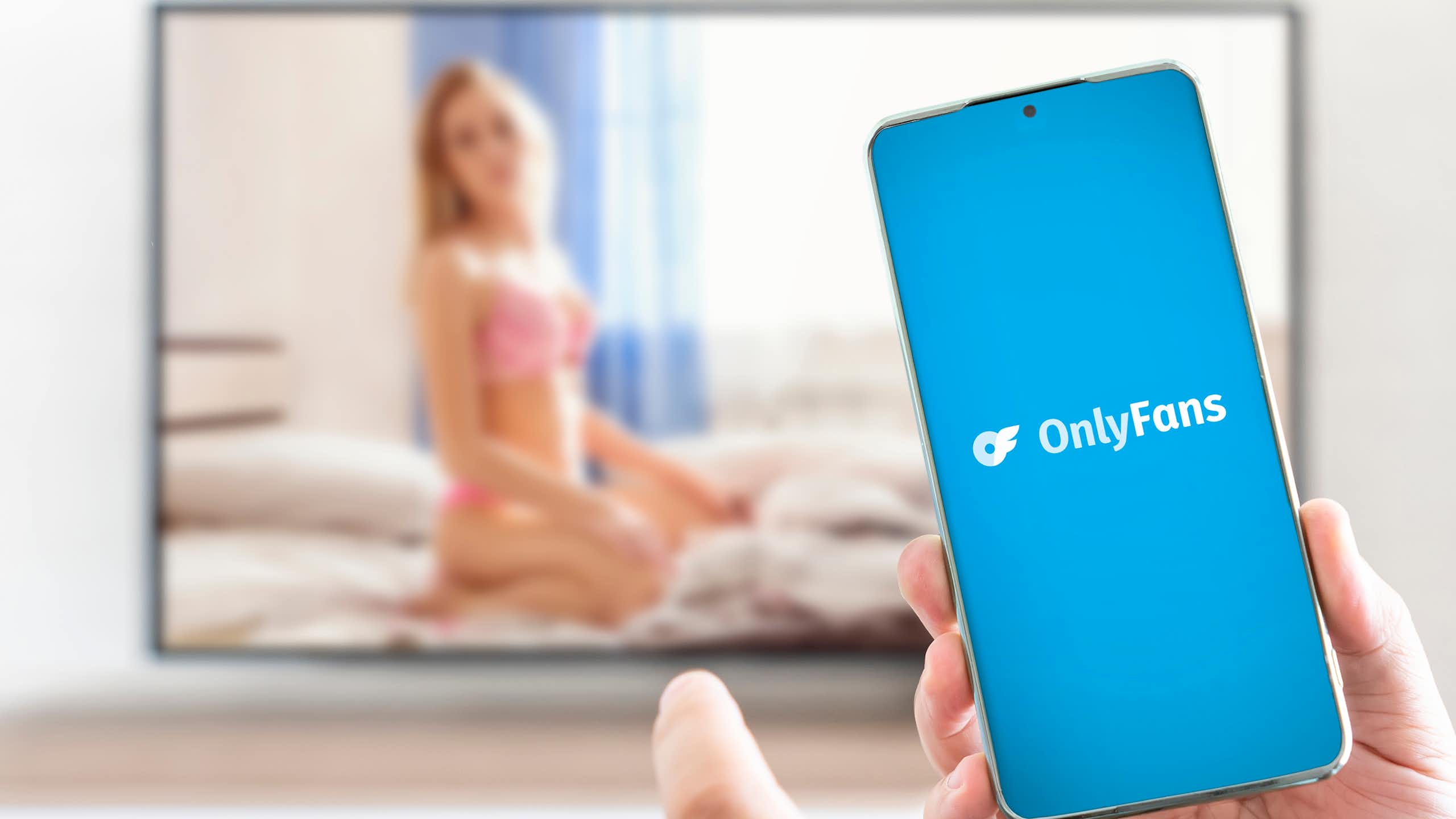 Personne avec un portable ouvrant l'application OnlyFans.