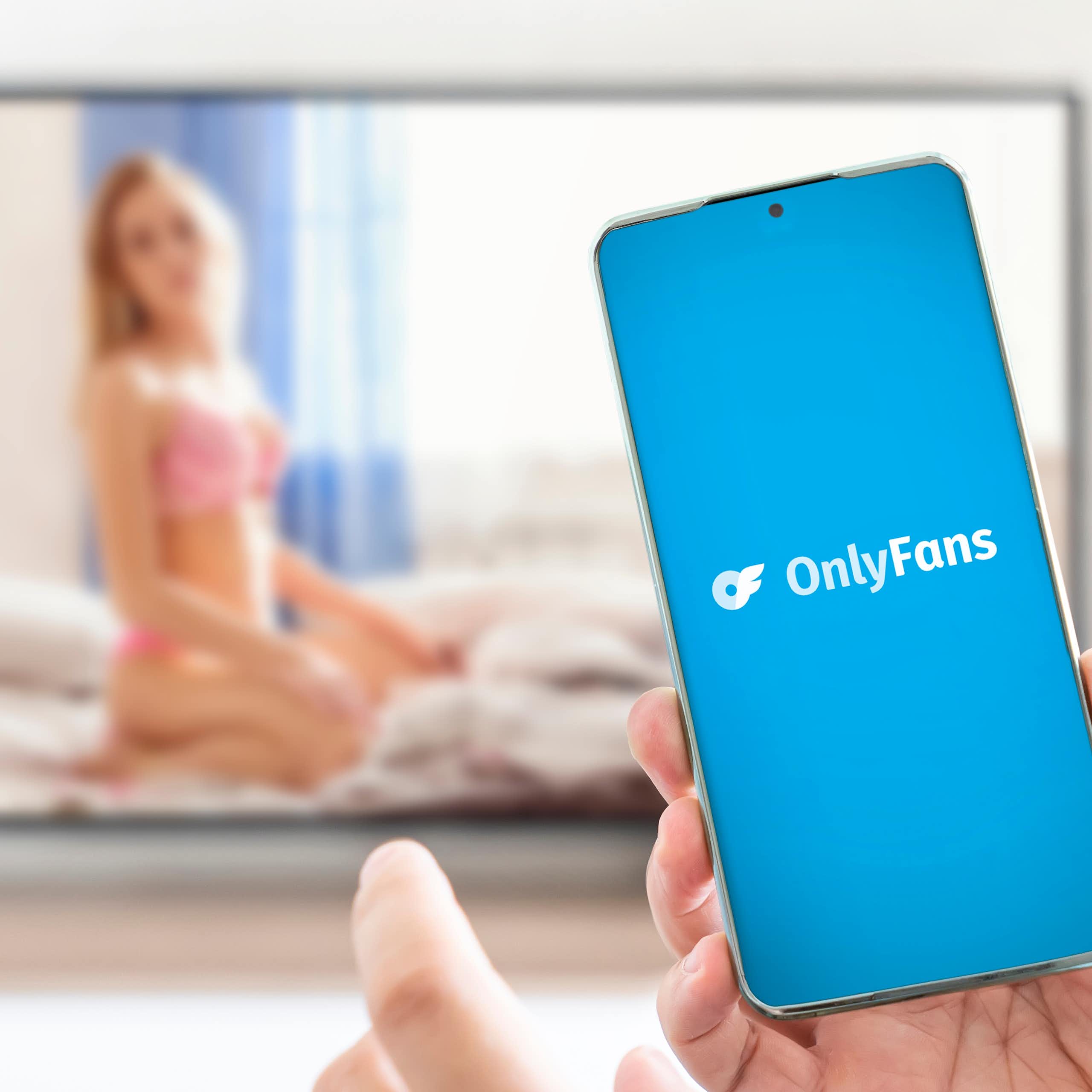 Personne avec un portable ouvrant l'application OnlyFans.