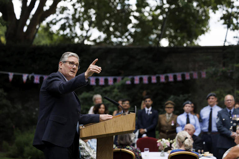 Keir Starmer pointing into the sky during a speech.