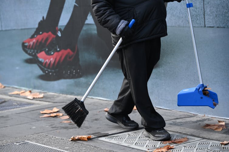 A cleaning worker sweeps leaves in the central business district in Melbourne