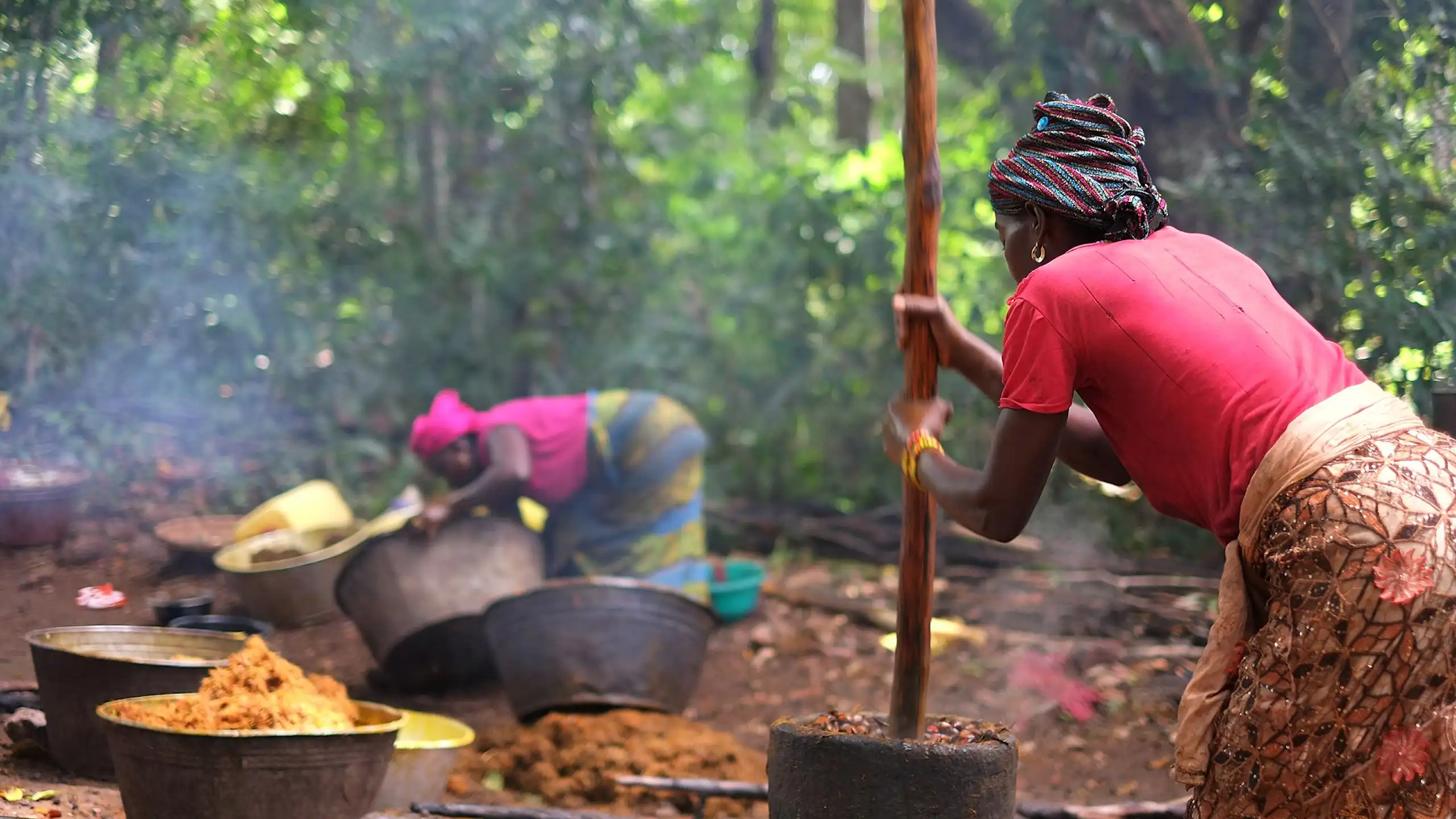 women processing palm oil in forest