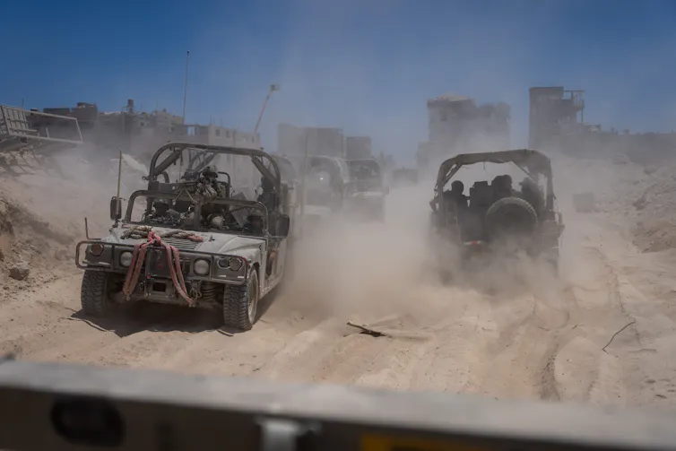 Israeli army vehicles transporting a group of soldiers and journalists inside the southern Gaza Strip.