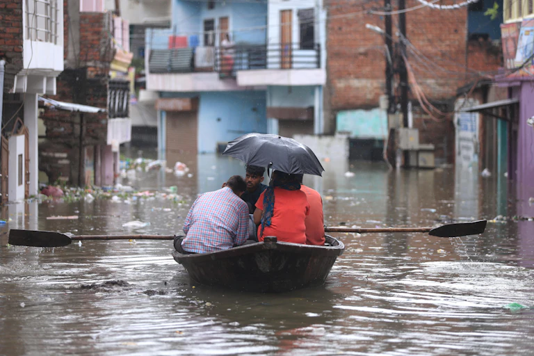 People on a small boat in flooded city