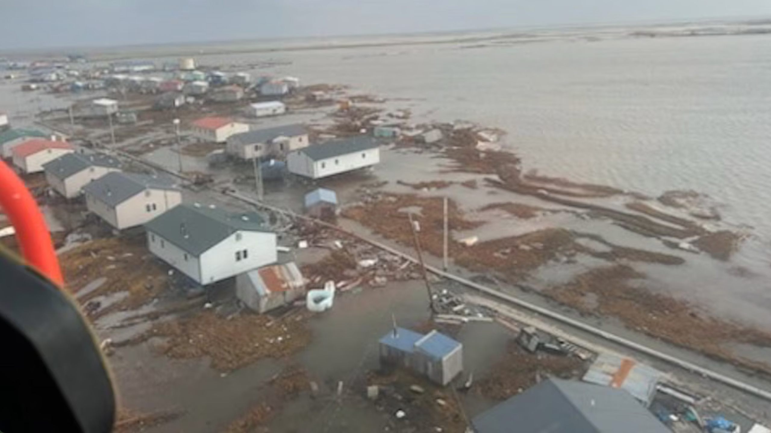 A view from a helicopter of floodwater surrounding homes.