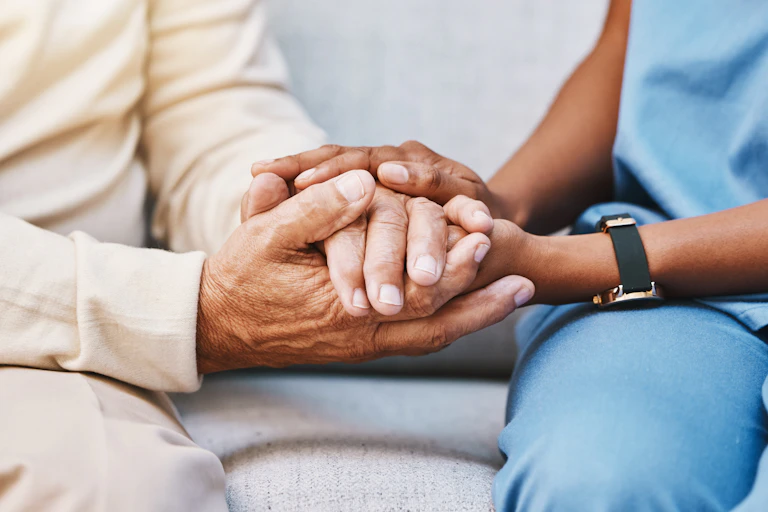 A medic holds a patients hands.