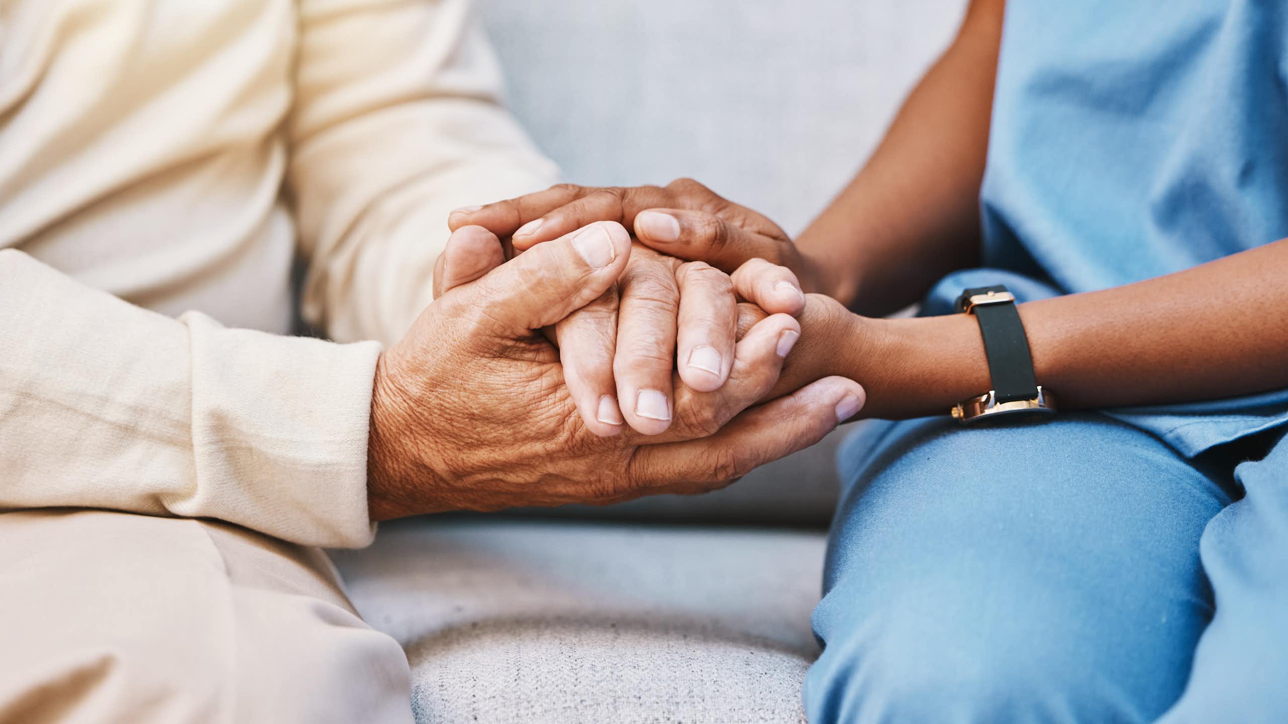 A medic holds a patients hands.