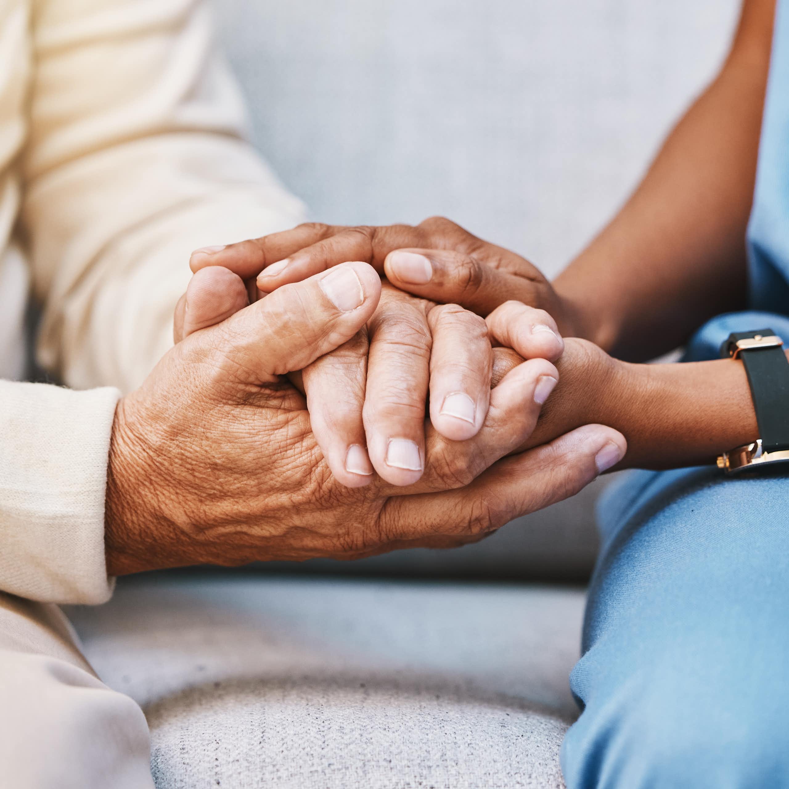 A medic holds a patients hands.