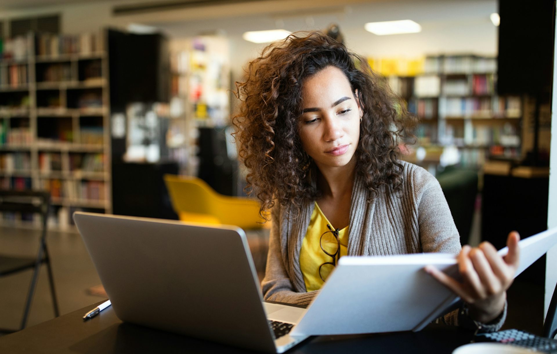 Une étudiante en bibliothèque avec un ordinateur