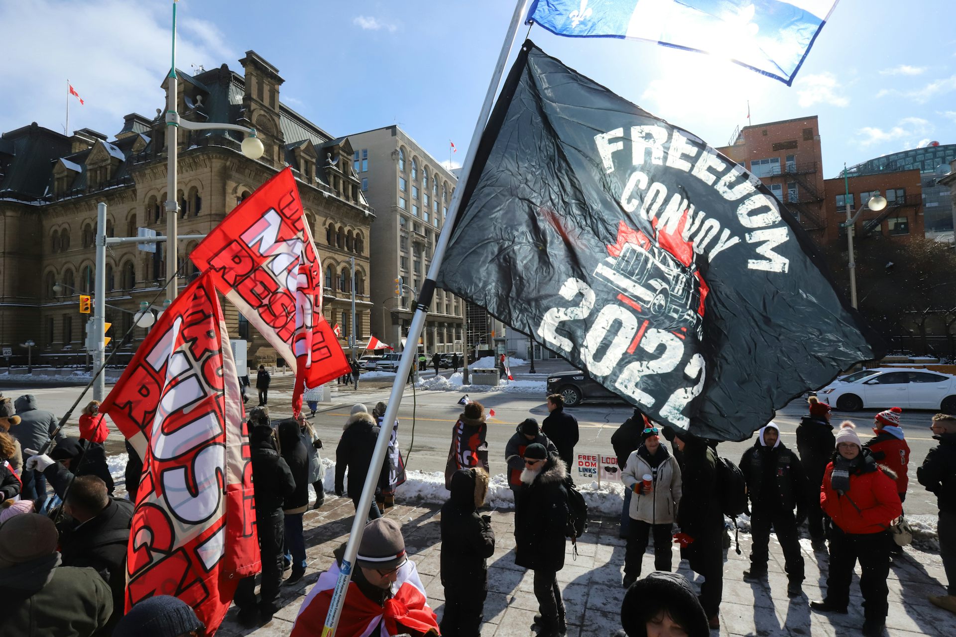 Personas que llevan carteles que dicen un convoy de libertad 2022