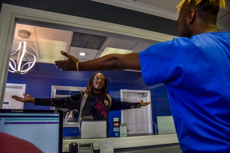 Patient greeting a person working at a clinic with open arms