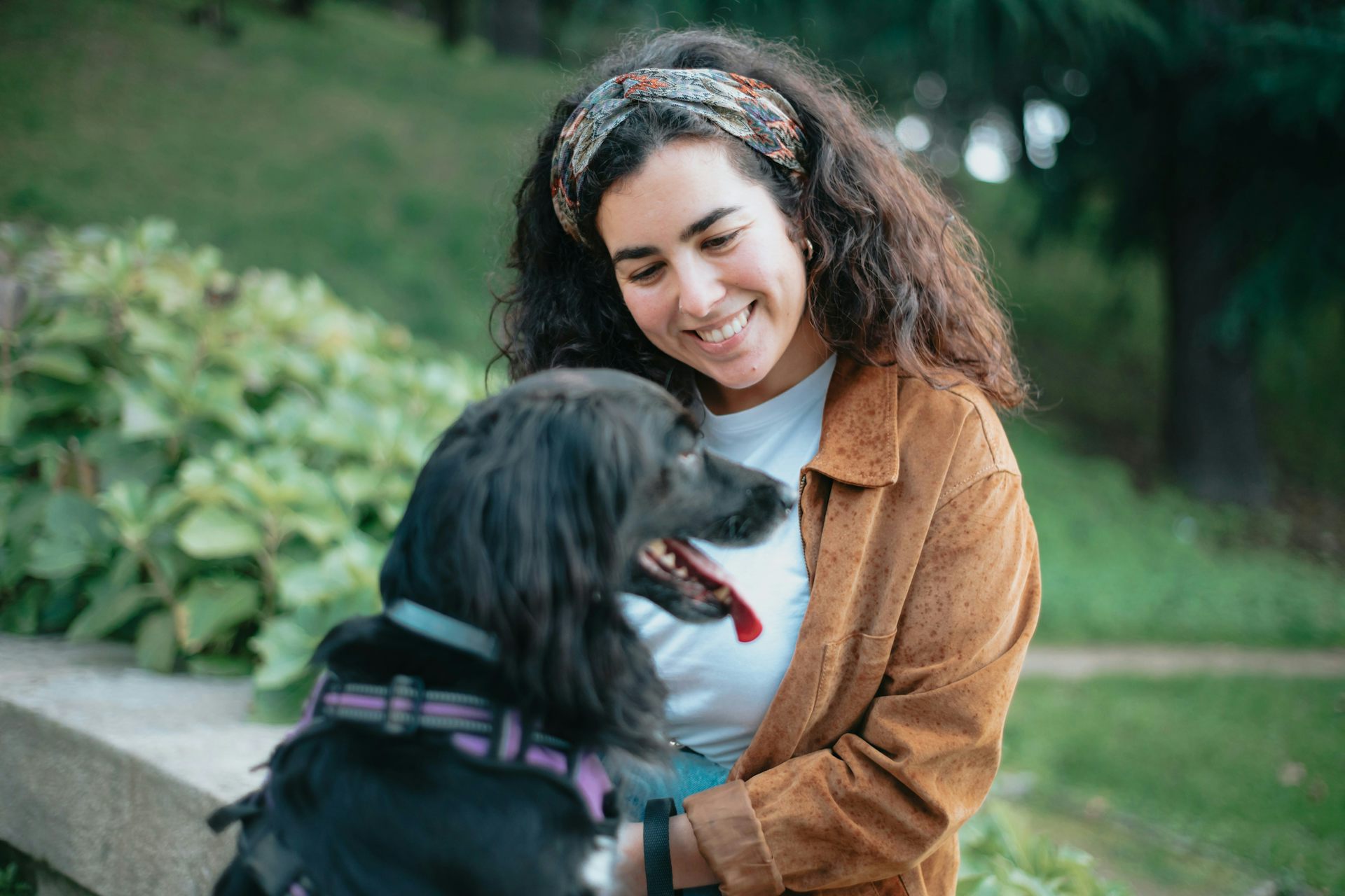 A woman smiling at a black dog