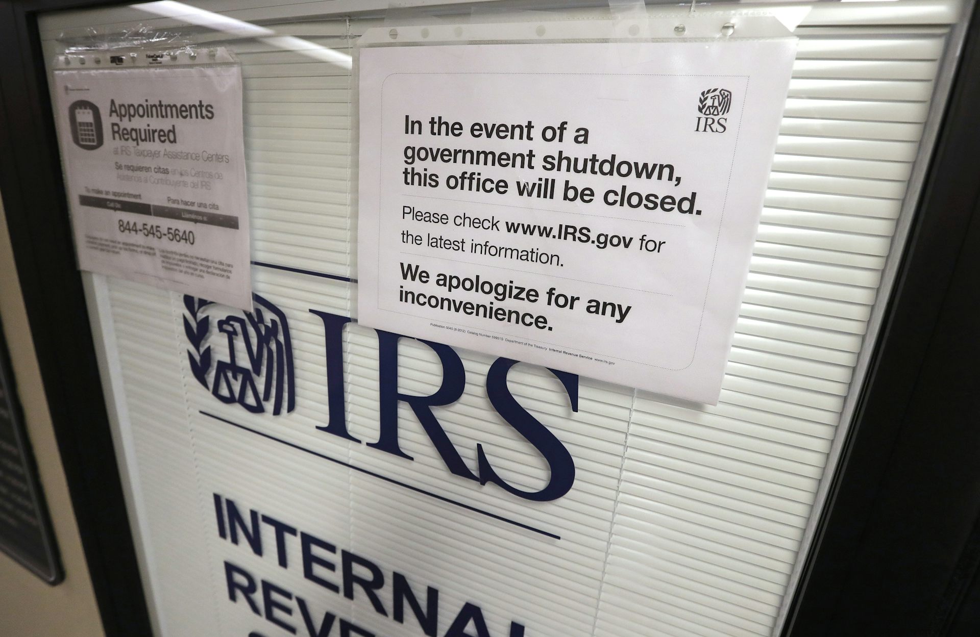 A sign on a door warns people that during a partial government shutdown, the IRS office will be closed.