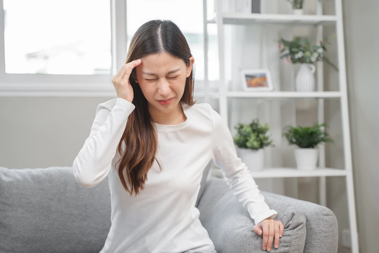 Young woman touching head as if in severe pain