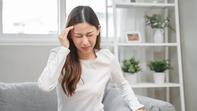 Young woman touching head as if in severe pain