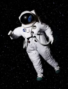 An astronaut wearing a space suit floating in space.