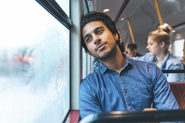 Man on a bus gazes out the window