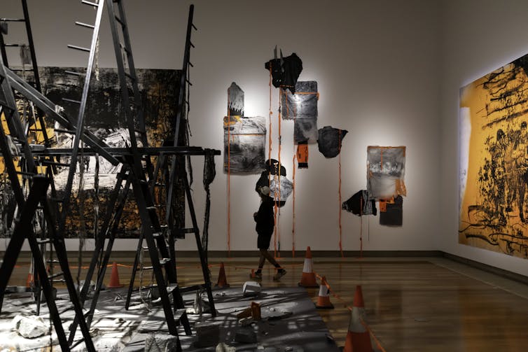 Wreckage crashes through the ceiling with ladders stretching to the floor