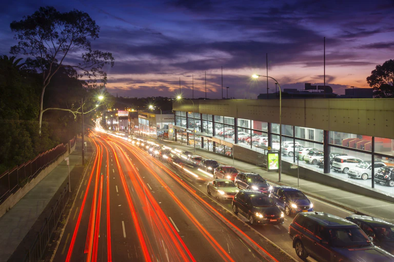 long-exposure shot of car taillights at dusk and cars stuck in traffic.