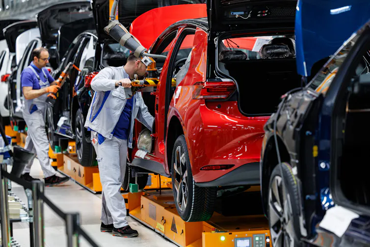 workers assembling an electric car.