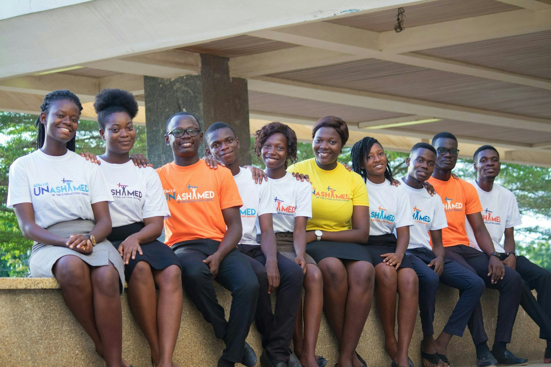 Young people sitting in a row wearing similar T-shirts
