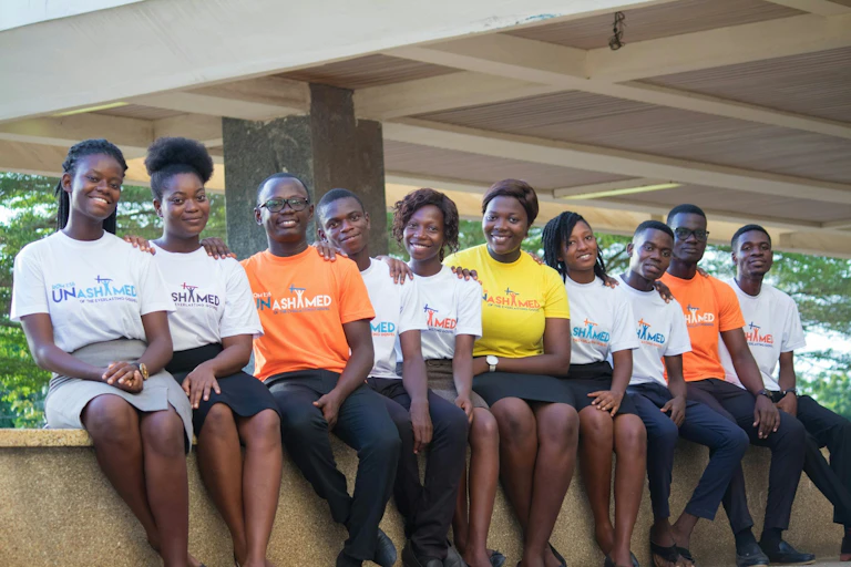 Young people sitting in a row wearing similar T-shirts