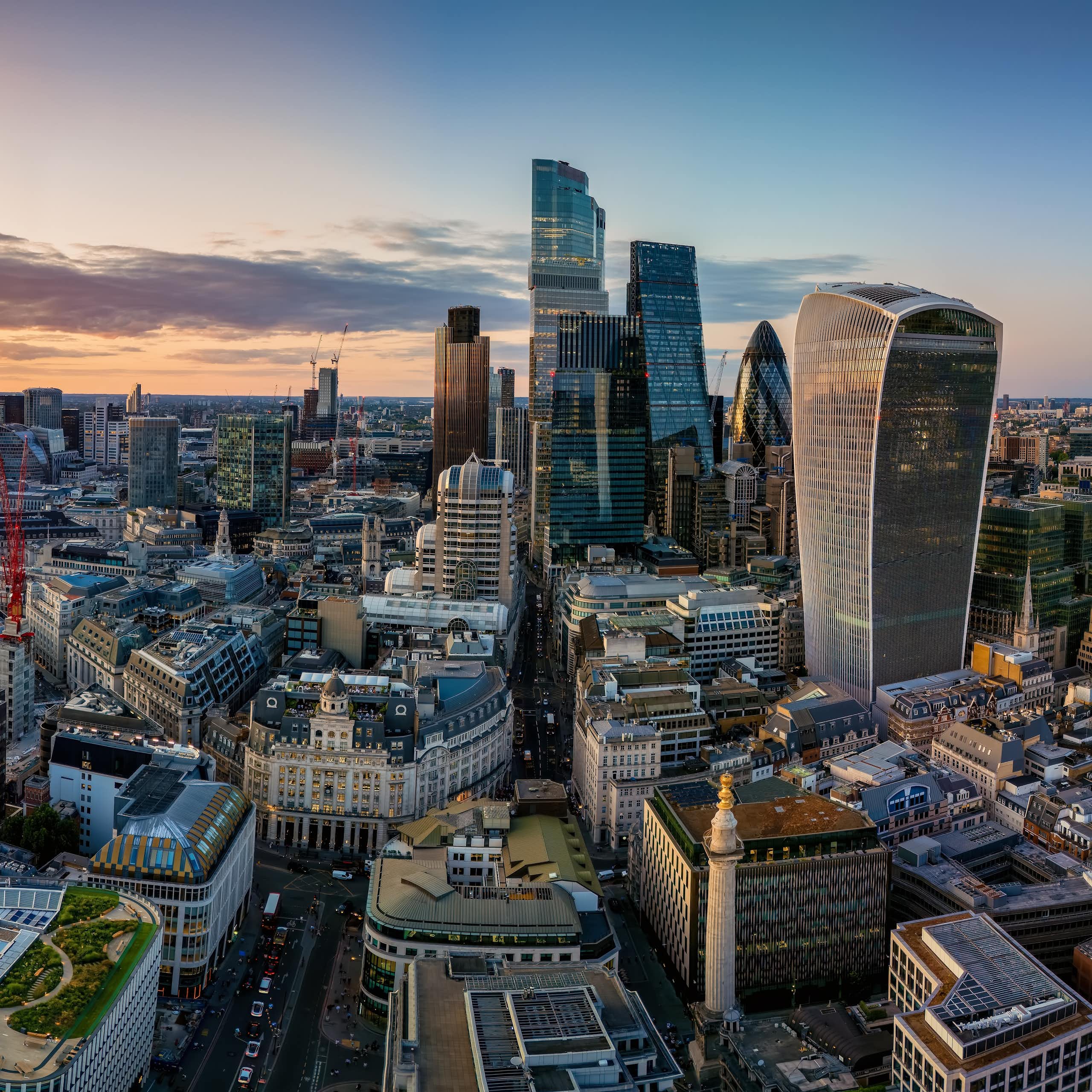 Aerial view of the City of London skyline with Moonument landmark and office skyscrapers during sunset time, England