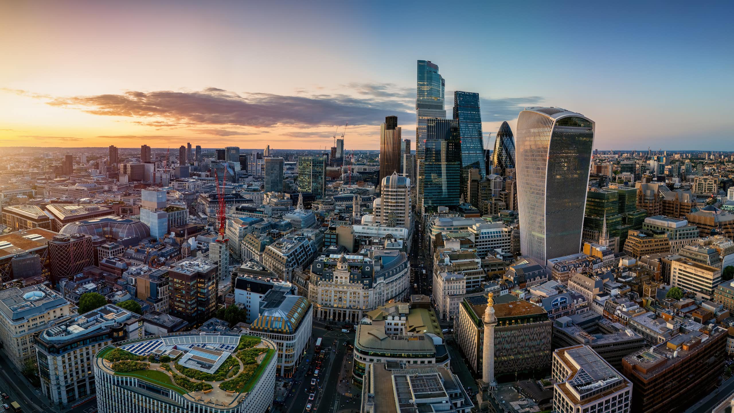 Aerial view of the City of London skyline with Moonument landmark and office skyscrapers during sunset time, England