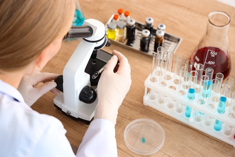 Une femme dans un laboratoire avec un microscope.